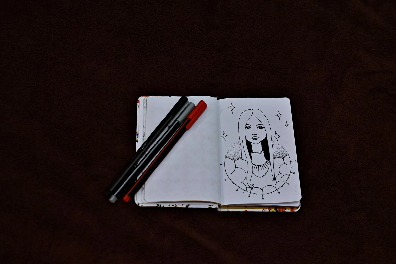 Bản vẽ nhân vật kiểu manga trong sổ tay trên nền tối